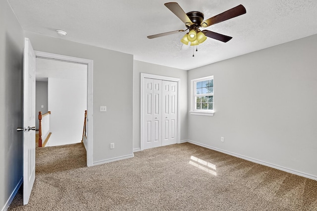 717 Monterrey Rd NE, Rio Rancho, NM 87144 - unfurnished bedroom featuring carpet flooring, a closet, ceiling fan, and a textured ceiling