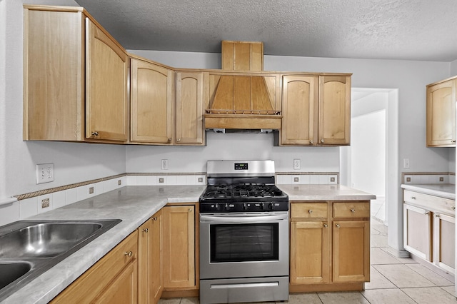 717 Monterrey Rd NE, Rio Rancho, NM 87144 - kitchen with stainless steel range with gas cooktop, a textured ceiling, custom range hood, light tile patterned floors, and light countertops
