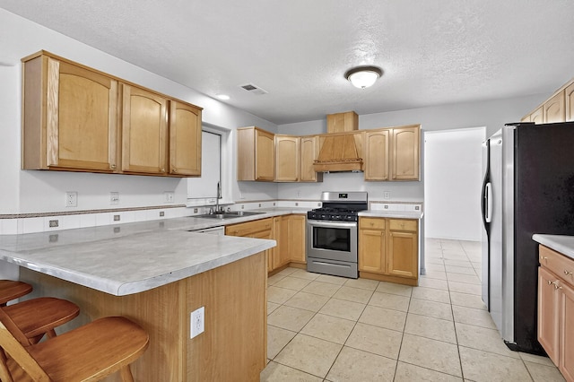 717 Monterrey Rd NE, Rio Rancho, NM 87144 - kitchen featuring stainless steel appliances, a peninsula, a textured ceiling, a kitchen breakfast bar, and light tile patterned floors