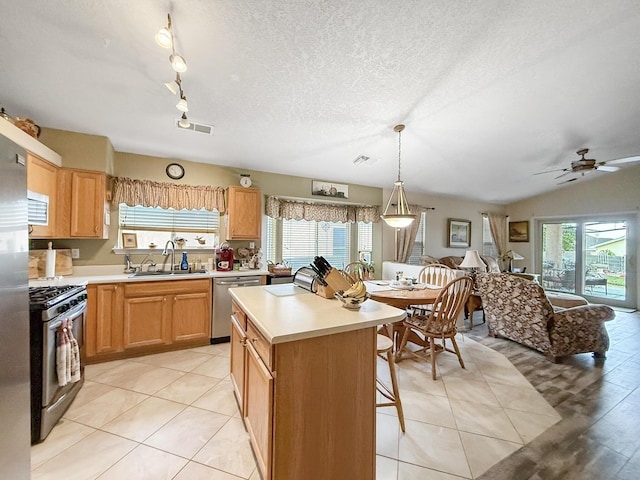 4532 Ambrose Alday Loop SE, Rio Rancho, NM 87124 - kitchen featuring appliances with stainless steel finishes, a sink, light countertops, a center island, and a textured ceiling