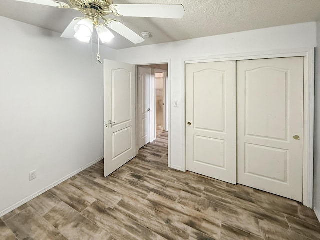 4532 Ambrose Alday Loop SE, Rio Rancho, NM 87124 - unfurnished bedroom featuring wood finished floors, a closet, baseboards, and ceiling fan