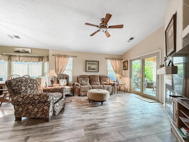 4532 Ambrose Alday Loop SE, Rio Rancho, NM 87124 - living room with a textured ceiling, a ceiling fan, a glass covered fireplace, and lofted ceiling