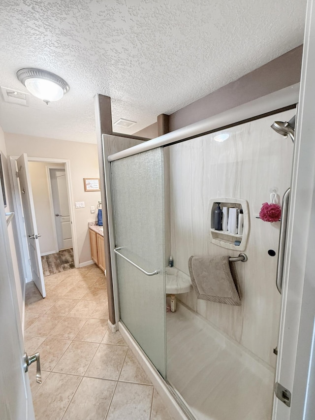 4532 Ambrose Alday Loop SE, Rio Rancho, NM 87124 - full bathroom featuring a shower stall, a textured ceiling, tile patterned flooring, vanity, and baseboards