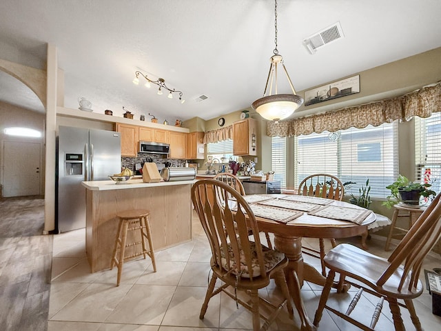4532 Ambrose Alday Loop SE, Rio Rancho, NM 87124 - dining area with arched walkways, healthy amount of natural light, lofted ceiling, and light tile patterned floors