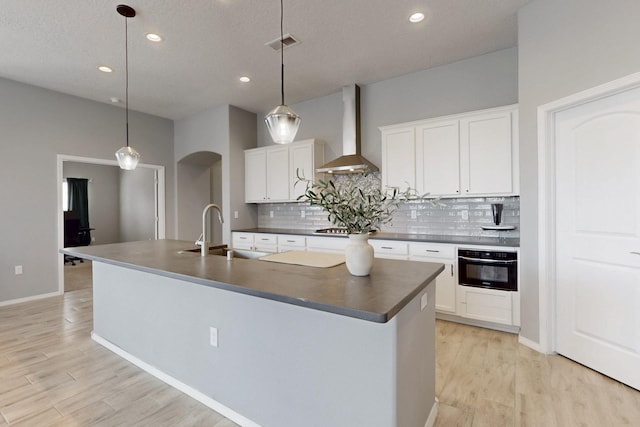 7037 Cleary Loop NE, Rio Rancho, NM 87144 - kitchen with wall chimney range hood, oven, dark countertops, tasteful backsplash, and recessed lighting