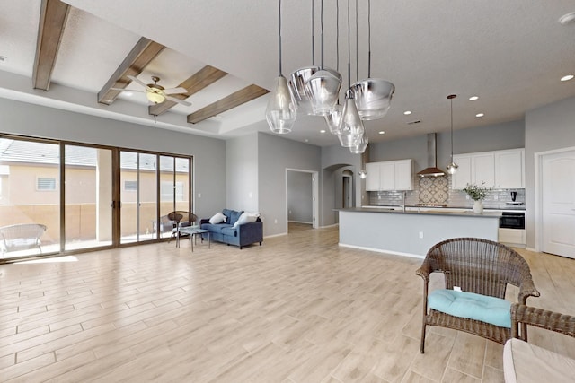 7037 Cleary Loop NE, Rio Rancho, NM 87144 - living room with arched walkways, a ceiling fan, light wood-style flooring, beam ceiling, and recessed lighting