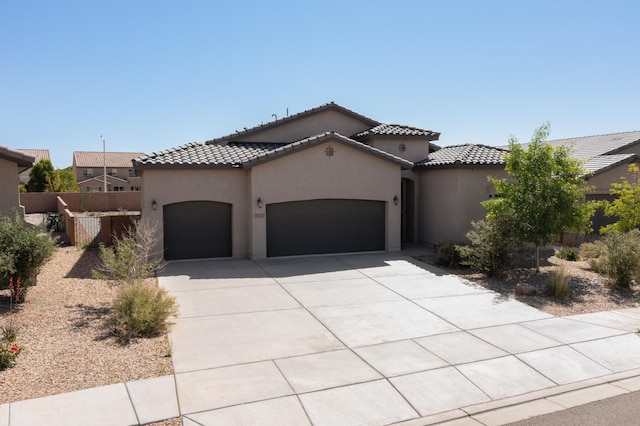 7037 Cleary Loop NE, Rio Rancho, NM 87144 - mediterranean / spanish-style house with a garage, driveway, stucco siding, and a tile roof