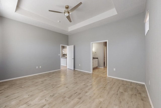 7037 Cleary Loop NE, Rio Rancho, NM 87144 - unfurnished bedroom with a raised ceiling, light wood-style floors, baseboards, a high ceiling, and ensuite bath