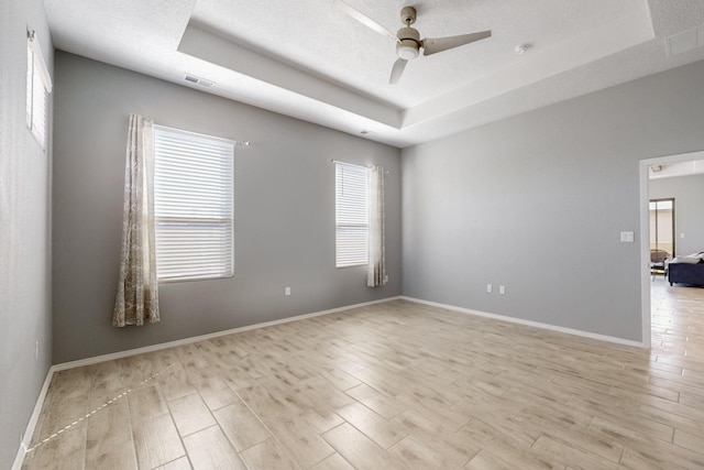 7037 Cleary Loop NE, Rio Rancho, NM 87144 - spare room featuring a tray ceiling, ceiling fan, light wood-style flooring, and baseboards