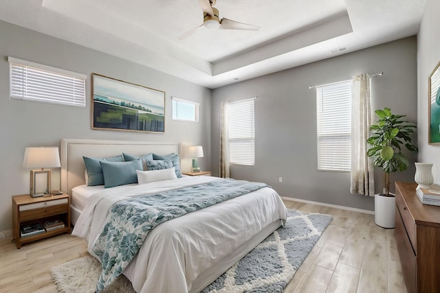 7037 Cleary Loop NE, Rio Rancho, NM 87144 - bedroom featuring a raised ceiling, light wood-type flooring, baseboards, and a ceiling fan