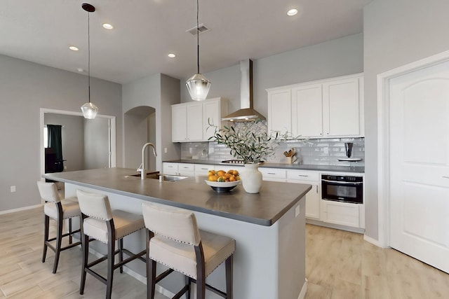 7037 Cleary Loop NE, Rio Rancho, NM 87144 - kitchen with wall chimney range hood, dark countertops, oven, decorative backsplash, and recessed lighting