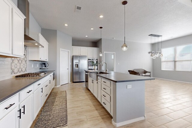 7037 Cleary Loop NE, Rio Rancho, NM 87144 - kitchen with appliances with stainless steel finishes, dark countertops, a sink, tasteful backsplash, and a center island with sink