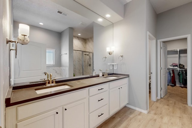 7037 Cleary Loop NE, Rio Rancho, NM 87144 - bathroom with a shower stall, double vanity, wood finished floors, a walk in closet, and toilet