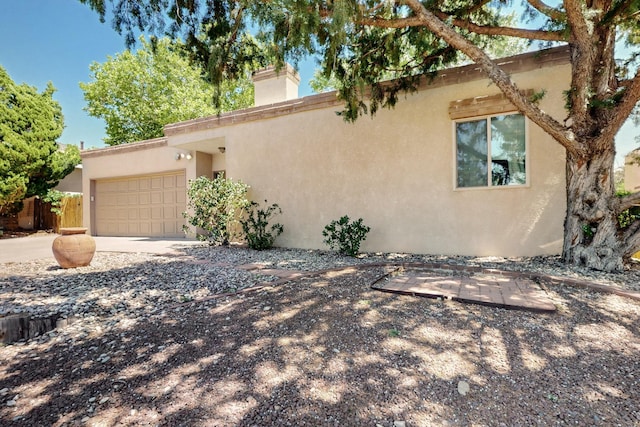 12304 Phoenix Ave NE, Albuquerque, NM 87112 - view of front of home with stucco siding, a chimney, an attached garage, and concrete driveway