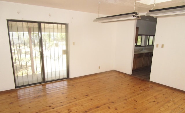 212 E Tingley Ave, Moriarty, NM 87035 - empty room with wood-type flooring and a sink