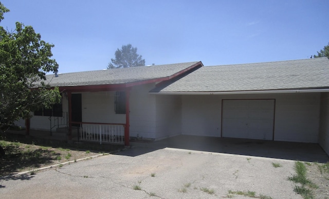 212 E Tingley Ave, Moriarty, NM 87035 - view of front of house featuring a shingled roof, an attached garage, asphalt driveway, and a porch