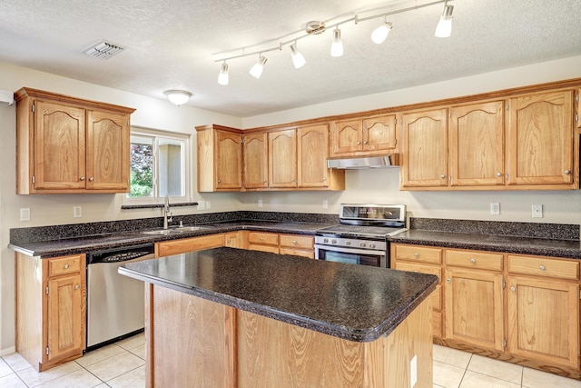 6923 Luz Del Sol Pl NW, Albuquerque, NM 87114 - kitchen featuring stainless steel appliances, a sink, under cabinet range hood, light tile patterned floors, and a textured ceiling