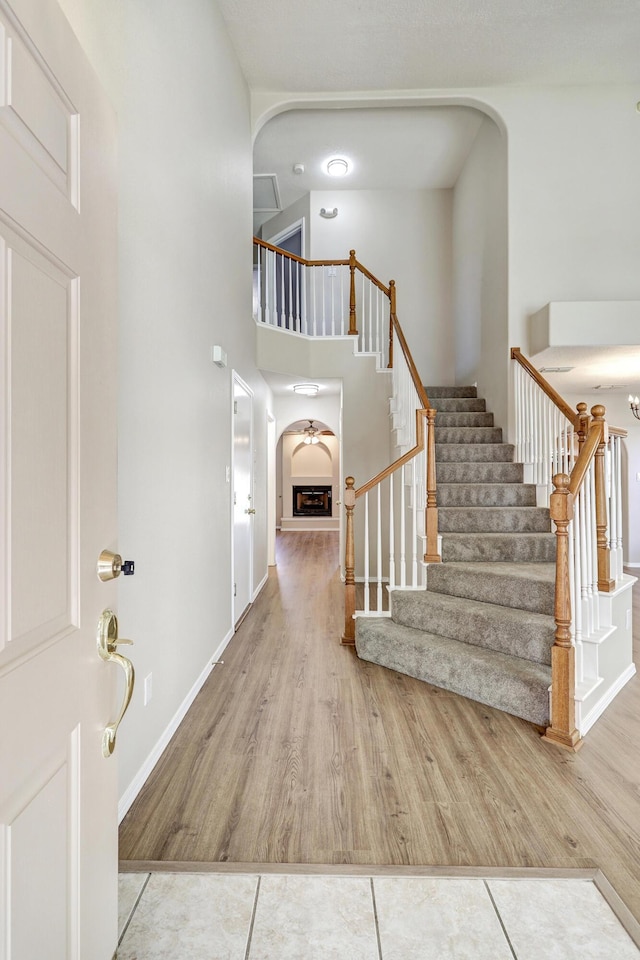 6923 Luz Del Sol Pl NW, Albuquerque, NM 87114 - entrance foyer with stairs, a towering ceiling, arched walkways, and wood finished floors
