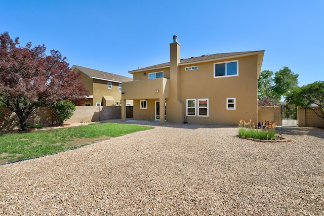 6923 Luz Del Sol Pl NW, Albuquerque, NM 87114 - back of property with stucco siding, a chimney, and a gate
