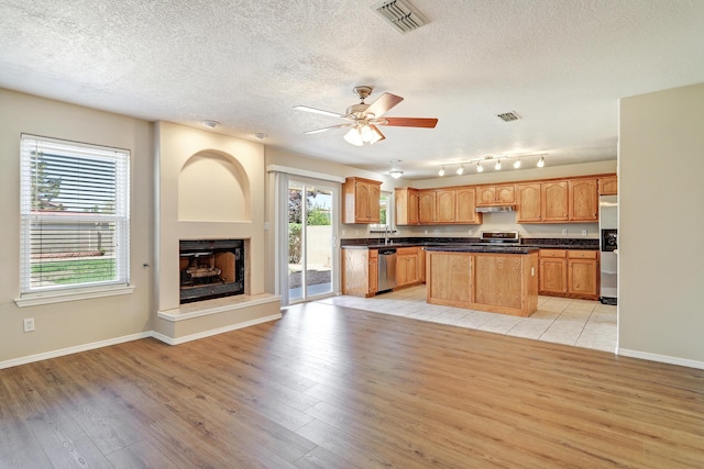 6923 Luz Del Sol Pl NW, Albuquerque, NM 87114 - kitchen featuring appliances with stainless steel finishes, dark countertops, light wood-style flooring, and a textured ceiling