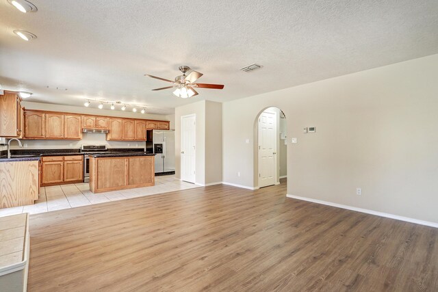 6923 Luz Del Sol Pl NW, Albuquerque, NM 87114 - kitchen with stainless steel appliances, open floor plan, ceiling fan, light wood finished floors, and a sink