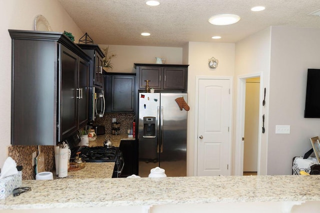 1019 Jacobs Dr NE, Rio Rancho, NM 87144 - kitchen with stainless steel appliances, a textured ceiling, backsplash, recessed lighting, and dark brown cabinetry