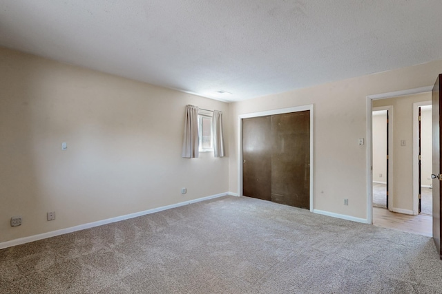 508 San Juan De Rio Dr SE, Rio Rancho, NM 87124 - unfurnished bedroom featuring light colored carpet, baseboards, and a closet