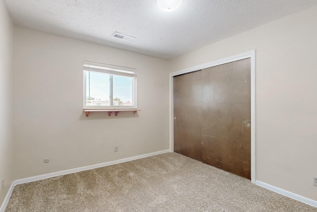 508 San Juan De Rio Dr SE, Rio Rancho, NM 87124 - unfurnished bedroom featuring carpet, a closet, a textured ceiling, and baseboards