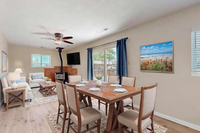 508 San Juan De Rio Dr SE, Rio Rancho, NM 87124 - dining area with a wood stove, light wood-type flooring, a ceiling fan, and baseboards