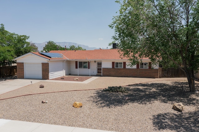 508 San Juan De Rio Dr SE, Rio Rancho, NM 87124 - ranch-style house featuring brick siding, driveway, solar panels, and an attached garage
