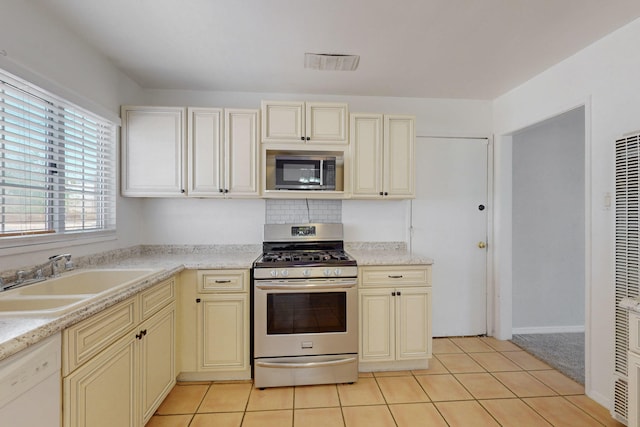 9913 Leyendecker Rd NE, Albuquerque, NM 87112 - kitchen with appliances with stainless steel finishes, cream cabinetry, a sink, a heating unit, and light tile patterned floors