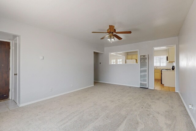 9913 Leyendecker Rd NE, Albuquerque, NM 87112 - unfurnished living room featuring ceiling fan, a heating unit, light colored carpet, and baseboards