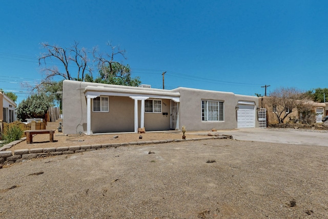 9913 Leyendecker Rd NE, Albuquerque, NM 87112 - pueblo revival-style home featuring stucco siding, an attached garage, and driveway