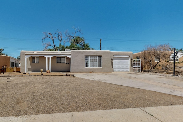 9913 Leyendecker Rd NE, Albuquerque, NM 87112 - adobe home with a garage, stucco siding, and concrete driveway