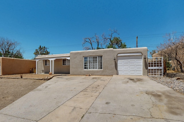 9913 Leyendecker Rd NE, Albuquerque, NM 87112 - southwest-style home featuring stucco siding, a garage, and concrete driveway