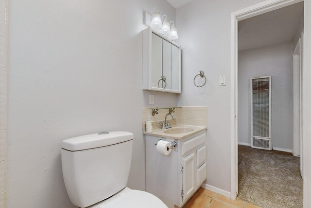 9913 Leyendecker Rd NE, Albuquerque, NM 87112 - bathroom with a heating unit, vanity, toilet, tile patterned floors, and baseboards
