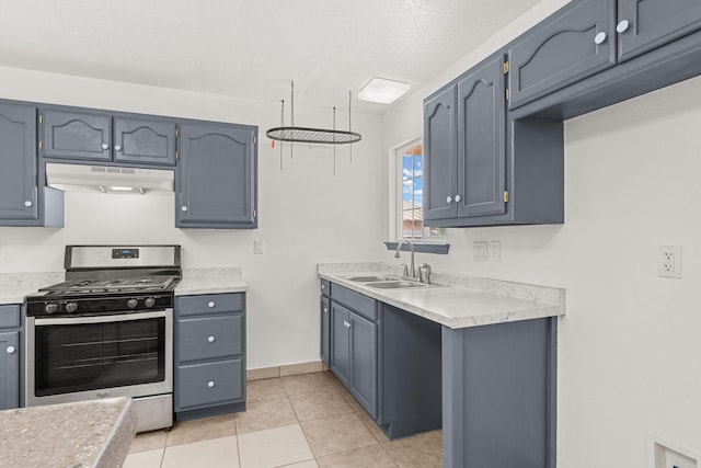 10504 W Connemara Ave SW, Albuquerque, NM 87121 - kitchen featuring stainless steel gas range oven, a sink, under cabinet range hood, light countertops, and light tile patterned flooring