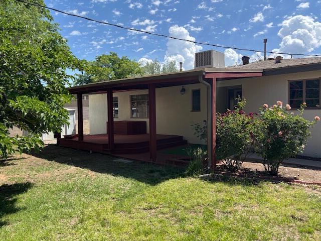 1723 Truman St NE, Albuquerque, NM 87110 - rear view of house with a lawn and stucco siding