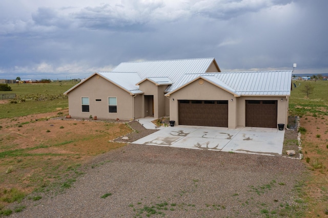 12 Kailey Loop, Edgewood, NM 87015 - view of front of home with a garage, stucco siding, driveway, and metal roof