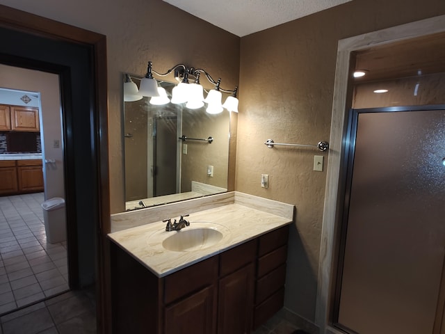 4111 El Cajon Ct SE, Rio Rancho, NM 87124 - bathroom featuring vanity, a stall shower, tile patterned flooring, a textured wall, and a textured ceiling