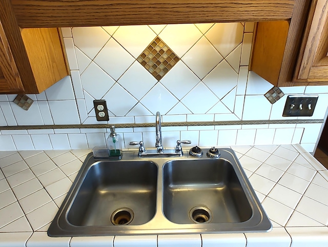 4111 El Cajon Ct SE, Rio Rancho, NM 87124 - kitchen view of tile counters, a sink, decorative backsplash, and brown cabinetry