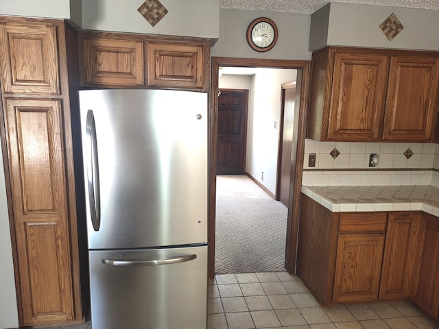 4111 El Cajon Ct SE, Rio Rancho, NM 87124 - kitchen featuring freestanding refrigerator, brown cabinets, and light tile patterned floors