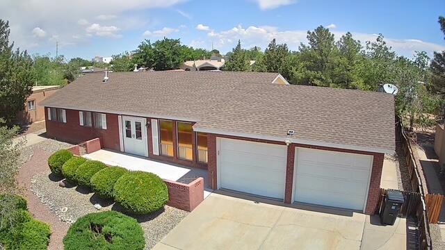 4111 El Cajon Ct SE, Rio Rancho, NM 87124 - ranch-style home with concrete driveway, an attached garage, and roof with shingles