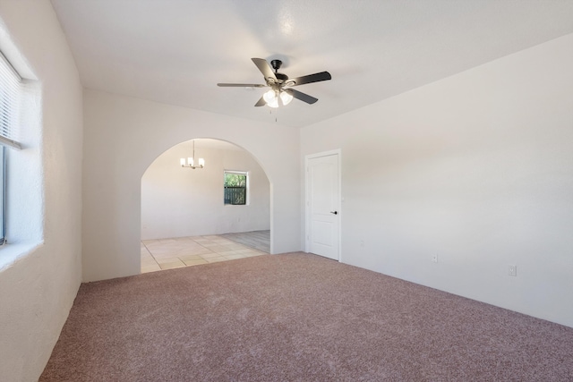 2012 Foothill Dr SW, Albuquerque, NM 87105 - unfurnished room with arched walkways, light carpet, ceiling fan, and light tile patterned floors
