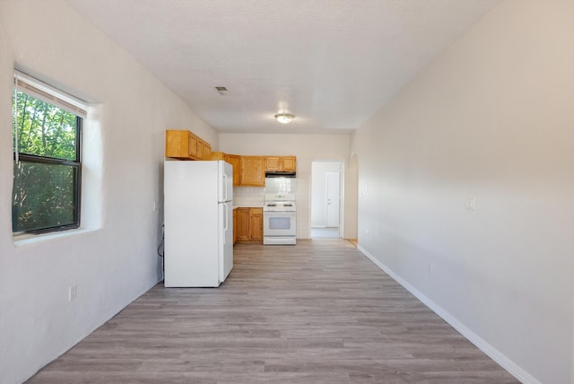 2012 Foothill Dr SW, Albuquerque, NM 87105 - kitchen with white appliances, under cabinet range hood, tasteful backsplash, light wood-type flooring, and light countertops