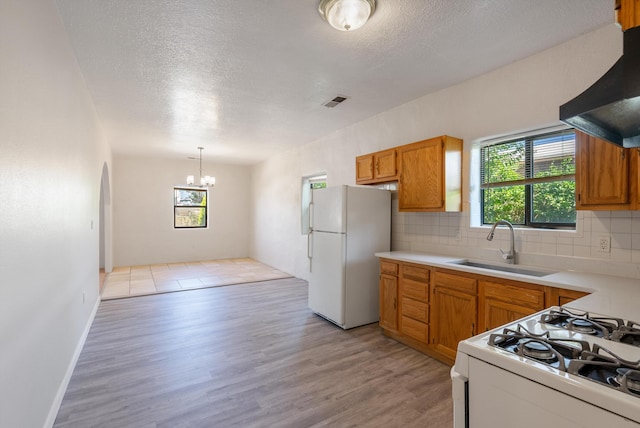 2012 Foothill Dr SW, Albuquerque, NM 87105 - kitchen with white appliances, exhaust hood, a chandelier, healthy amount of natural light, and a textured ceiling