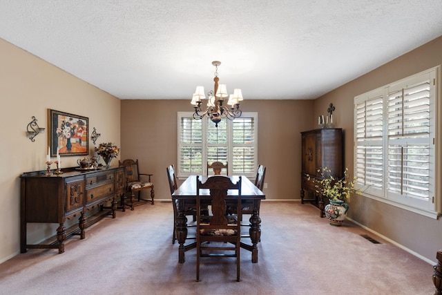 8480 Osuna Rd NE, Albuquerque, NM 87111 - dining room featuring a chandelier, light colored carpet, baseboards, and a textured ceiling