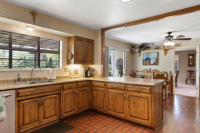 8480 Osuna Rd NE, Albuquerque, NM 87111 - kitchen featuring a sink, brick patterned floors, dishwasher, a peninsula, and brown cabinetry