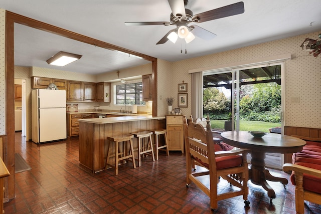 8480 Osuna Rd NE, Albuquerque, NM 87111 - dining room featuring wallpapered walls, brick patterned floors, and ceiling fan