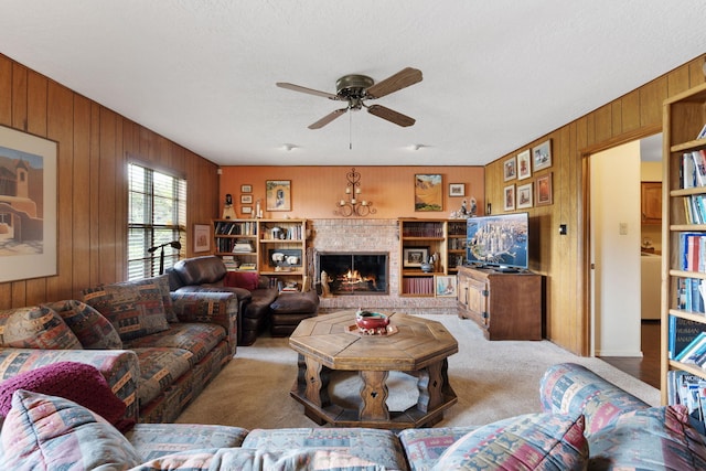 8480 Osuna Rd NE, Albuquerque, NM 87111 - living area with wood walls, light colored carpet, ceiling fan, a warm lit fireplace, and a textured ceiling